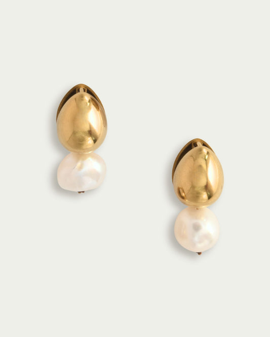 Gold and pearl earrings on a light background